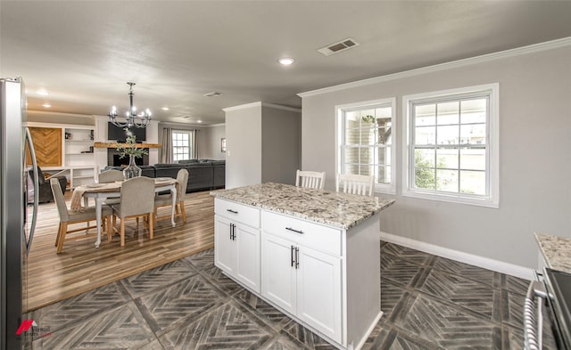 kitchen with visible vents, freestanding refrigerator, open floor plan, white cabinets, and baseboards