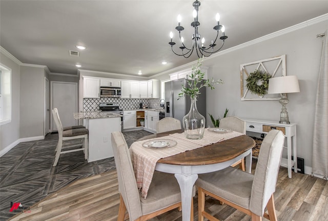 dining space featuring ornamental molding, visible vents, and wood finished floors