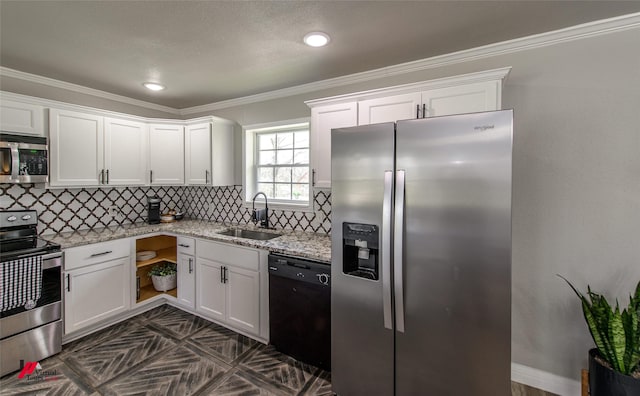 kitchen featuring light stone counters, a sink, white cabinets, appliances with stainless steel finishes, and decorative backsplash