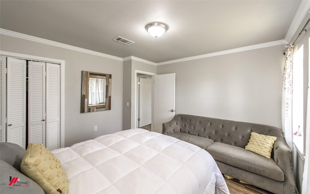 bedroom with crown molding, visible vents, and a closet