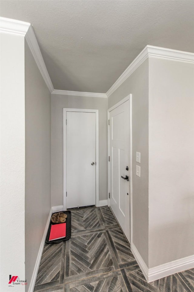 foyer entrance with a textured ceiling, baseboards, and crown molding