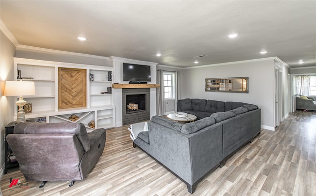 living room with recessed lighting, a brick fireplace, crown molding, and light wood finished floors