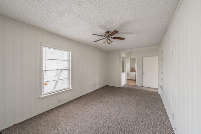 empty room with carpet, a ceiling fan, and a textured ceiling