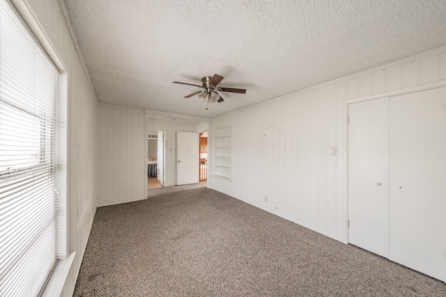 unfurnished bedroom featuring carpet, a closet, ceiling fan, and a textured ceiling