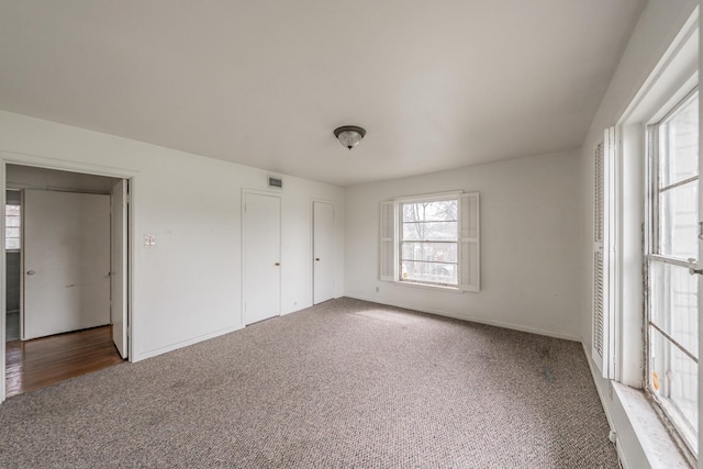 unfurnished bedroom featuring carpet and visible vents