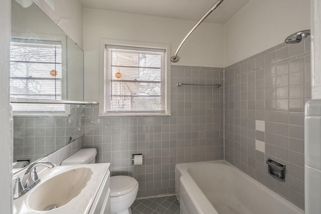 full bath with plenty of natural light, vanity, toilet, and tile walls