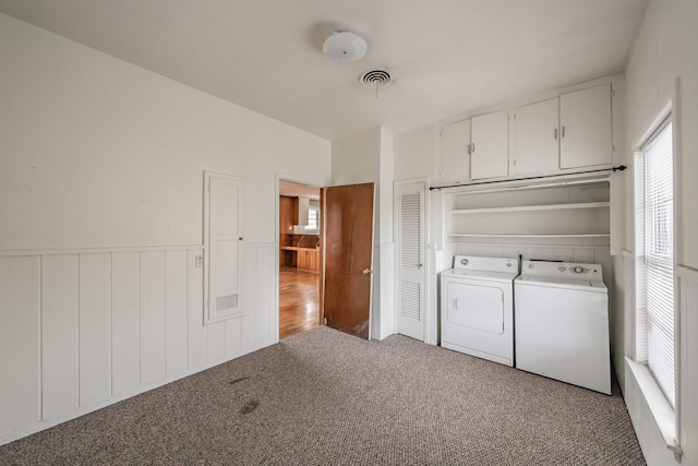 washroom with carpet, a wainscoted wall, visible vents, washing machine and dryer, and laundry area