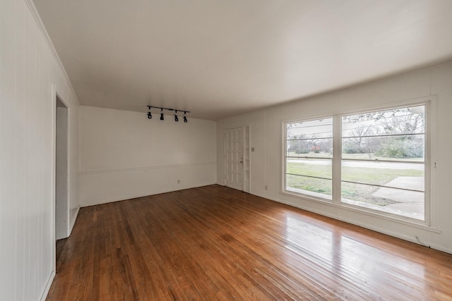 spare room featuring track lighting and hardwood / wood-style flooring