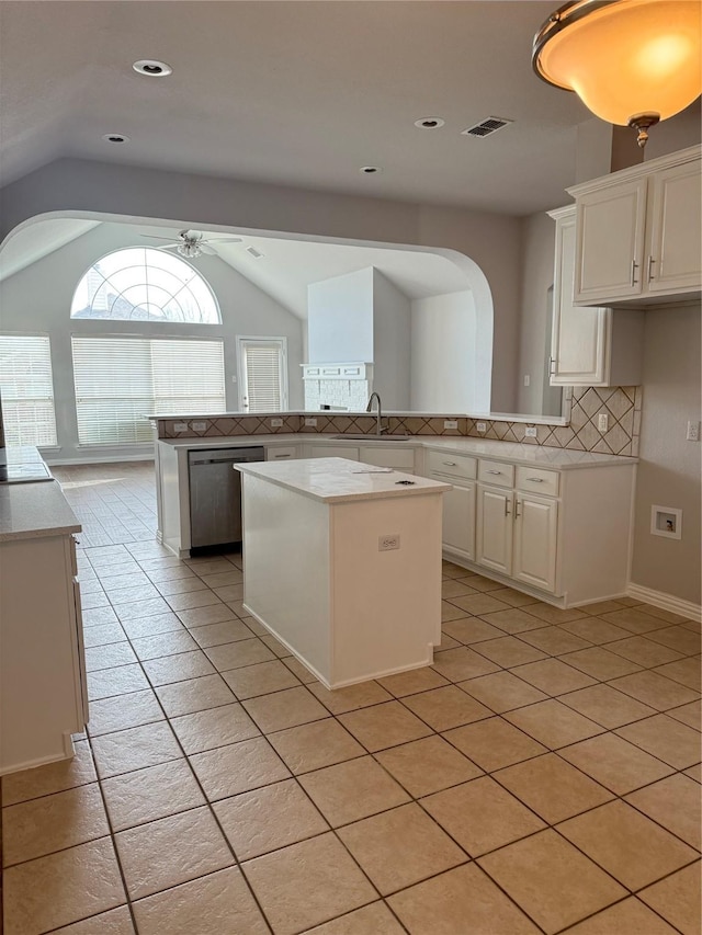 kitchen featuring tasteful backsplash, visible vents, a kitchen island, white cabinetry, and stainless steel dishwasher