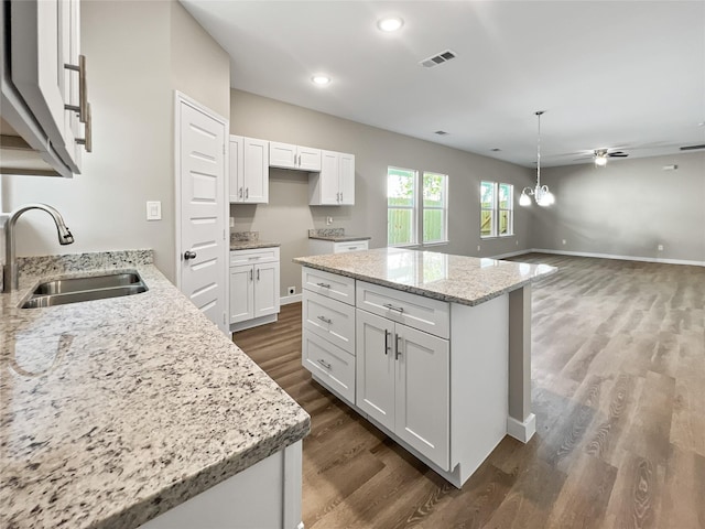 kitchen featuring white cabinetry, visible vents, a sink, and dark wood-style flooring