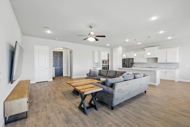 4303 Juniper Ln, Melissa, TX 75454 - living room featuring light wood-type flooring, visible vents, a ceiling fan, recessed lighting, and arched walkways