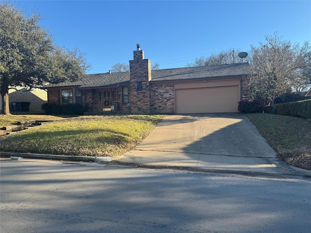 ranch-style home with brick siding, a chimney, concrete driveway, an attached garage, and a front yard