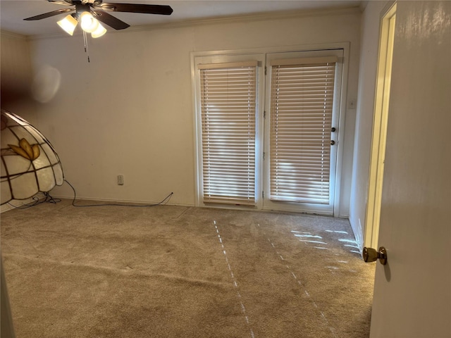 carpeted empty room featuring ceiling fan and ornamental molding