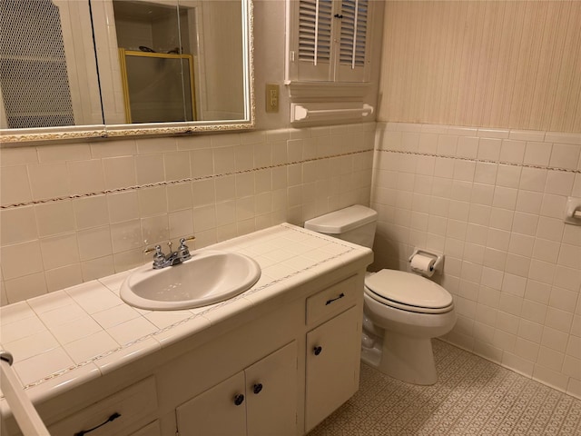 bathroom featuring wallpapered walls, toilet, tile patterned floors, vanity, and a shower stall