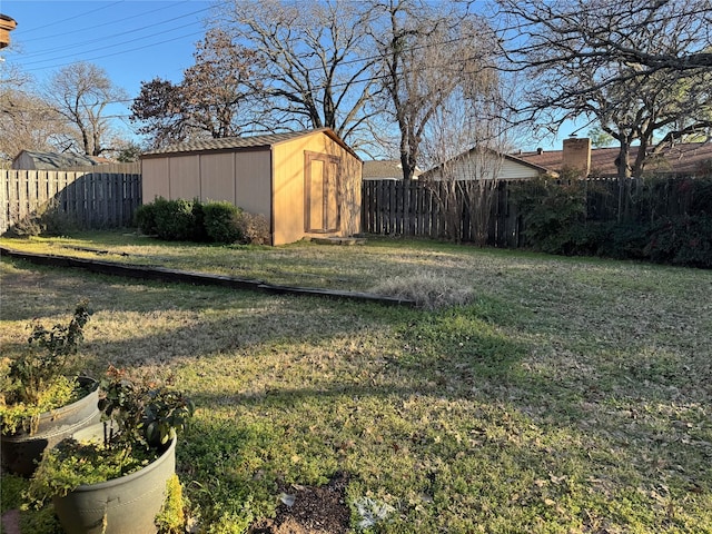 view of yard with a storage shed, a fenced backyard, and an outdoor structure