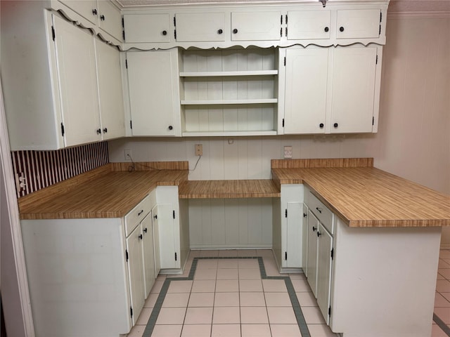 kitchen with a peninsula, light tile patterned floors, white cabinets, and light countertops