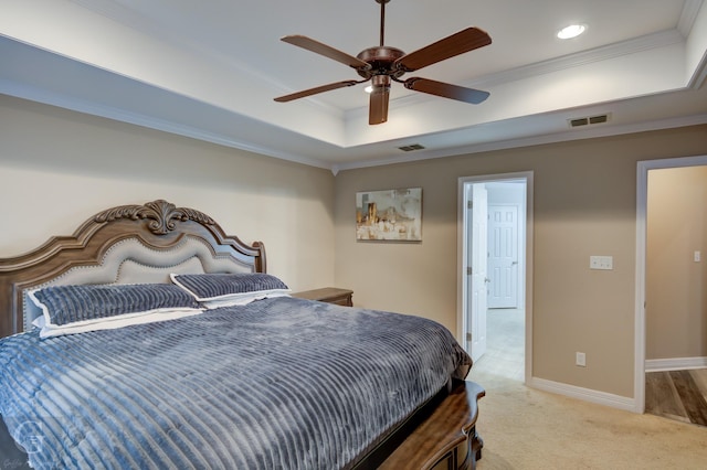 bedroom with light colored carpet, visible vents, baseboards, ornamental molding, and a tray ceiling