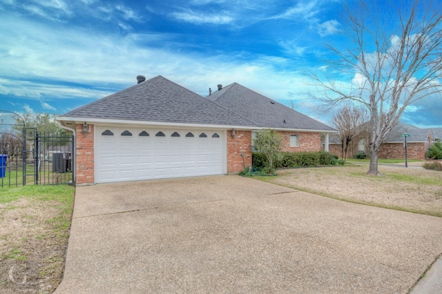 ranch-style house featuring a shingled roof, concrete driveway, and brick siding