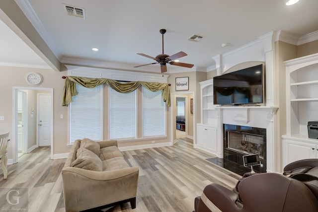 living area with light wood-style flooring, a fireplace with flush hearth, and visible vents