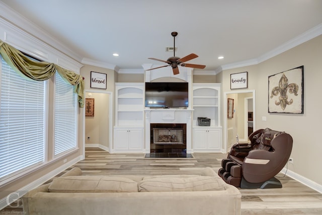 living area with crown molding, visible vents, a fireplace with flush hearth, wood finished floors, and baseboards