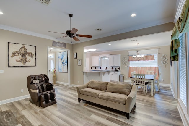 living area with baseboards, visible vents, crown molding, and light wood finished floors