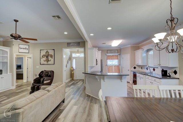 kitchen with dark countertops, white cabinetry, visible vents, and open floor plan