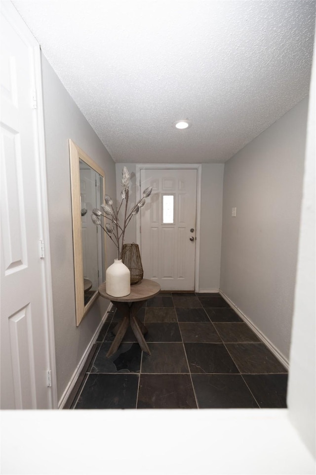 entryway with a textured ceiling and baseboards