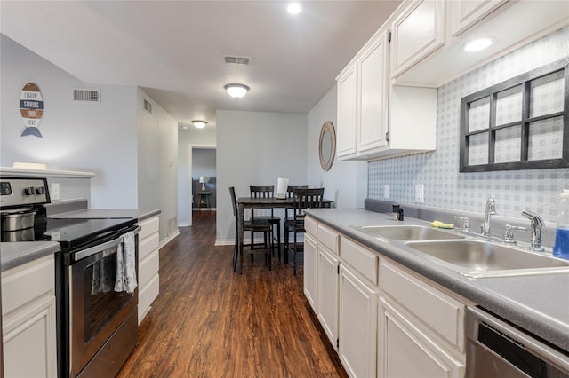 kitchen featuring dark wood-style floors, visible vents, appliances with stainless steel finishes, white cabinetry, and a sink