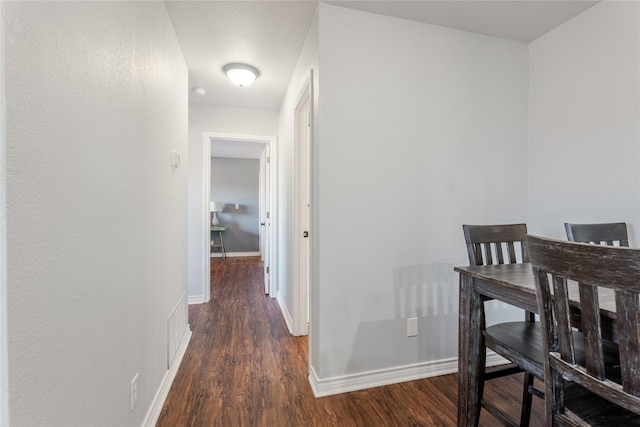 corridor with wood finished floors and baseboards