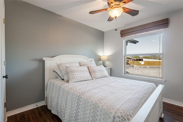 bedroom featuring dark wood finished floors, a ceiling fan, and baseboards