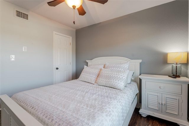 bedroom with dark wood-style floors, visible vents, and ceiling fan