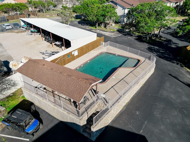 community pool with a fenced backyard and a patio