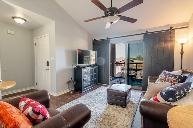 living area with lofted ceiling, ceiling fan, a barn door, wood finished floors, and baseboards