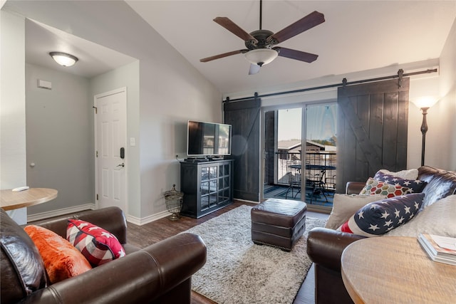 living area featuring lofted ceiling, a barn door, a ceiling fan, wood finished floors, and baseboards