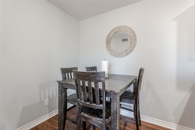 dining area with baseboards, visible vents, and dark wood-type flooring