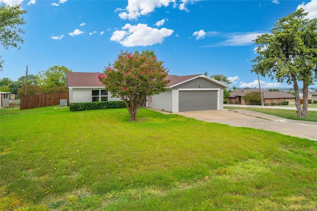 ranch-style house with an attached garage, fence, concrete driveway, and a front yard