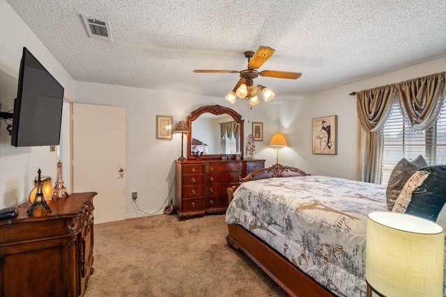 carpeted bedroom with ceiling fan, visible vents, and a textured ceiling