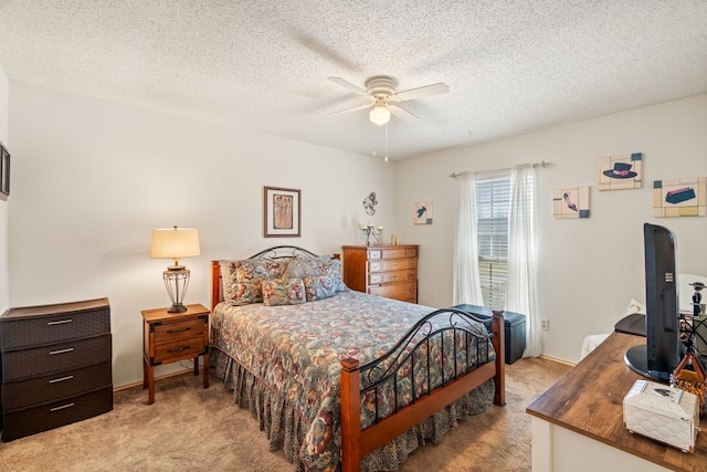 bedroom featuring light carpet, a ceiling fan, and a textured ceiling