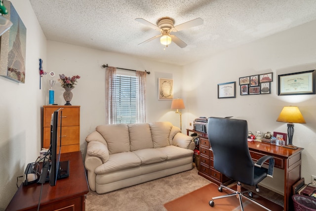 carpeted office space featuring ceiling fan and a textured ceiling