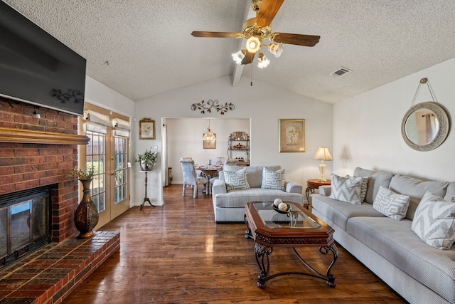 living area featuring vaulted ceiling with beams, a textured ceiling, a fireplace, and wood finished floors