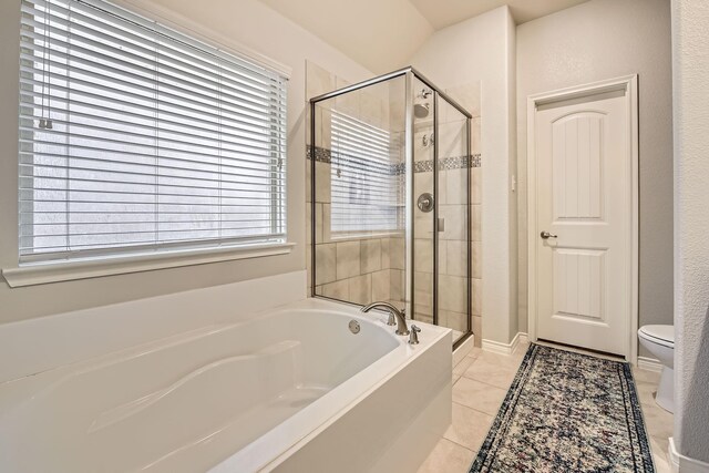 bathroom with tile patterned flooring, toilet, a bath, and a stall shower