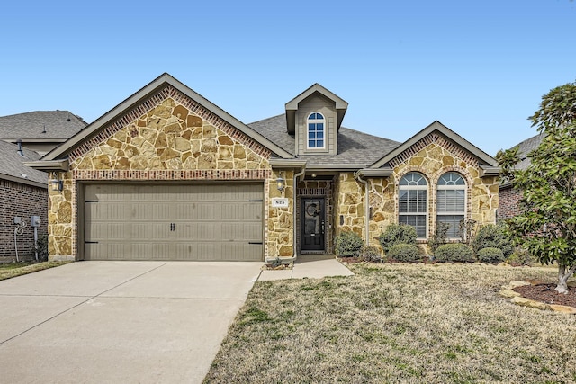 view of front of property with stone siding, driveway, an attached garage, and a shingled roof