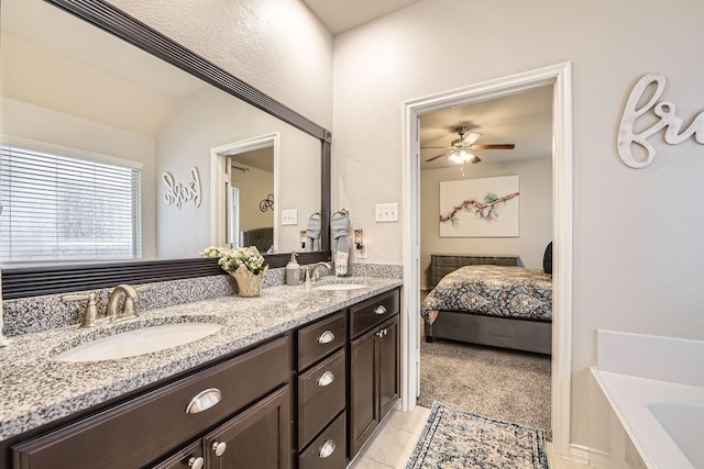 ensuite bathroom with a sink, connected bathroom, a bath, and tile patterned floors