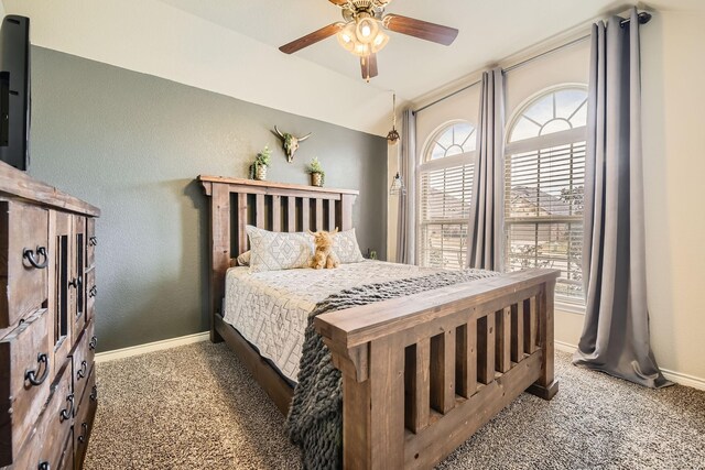 bedroom featuring a ceiling fan, carpet, baseboards, vaulted ceiling, and a textured wall