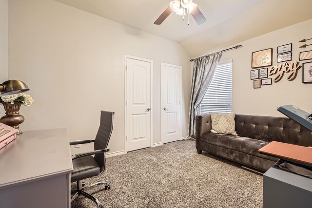 carpeted home office featuring baseboards, ceiling fan, and vaulted ceiling