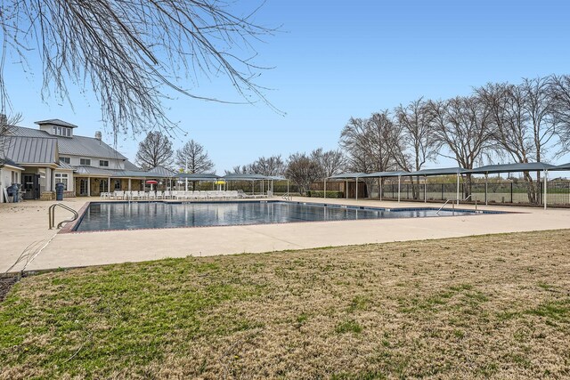 community pool featuring a yard, a patio, and fence