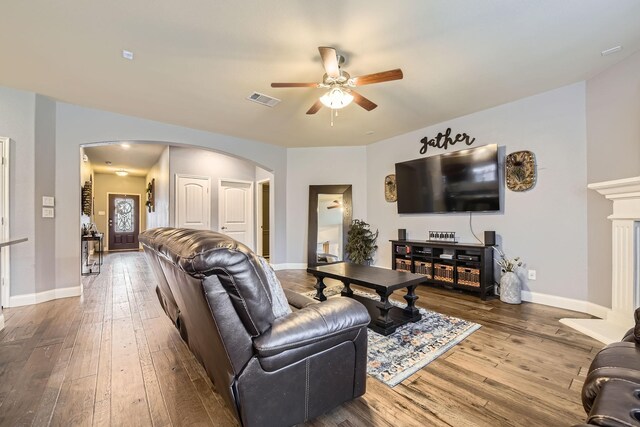 living room with visible vents, baseboards, arched walkways, ceiling fan, and hardwood / wood-style flooring