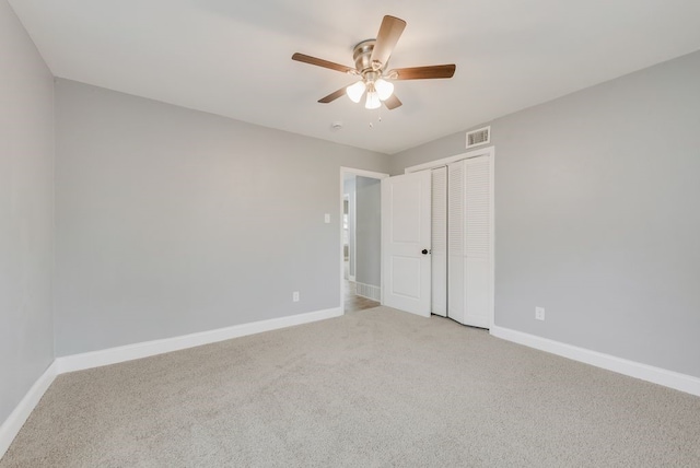 unfurnished bedroom with a ceiling fan, a closet, light colored carpet, and baseboards