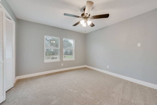 unfurnished bedroom with light carpet, ceiling fan, baseboards, and a closet