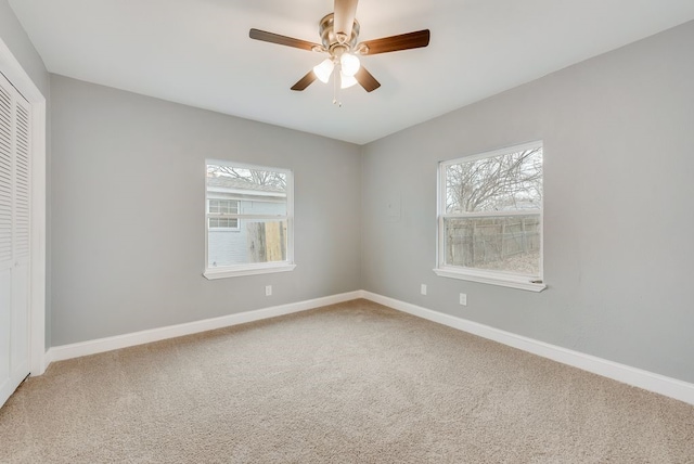 unfurnished room featuring a ceiling fan, light carpet, plenty of natural light, and baseboards